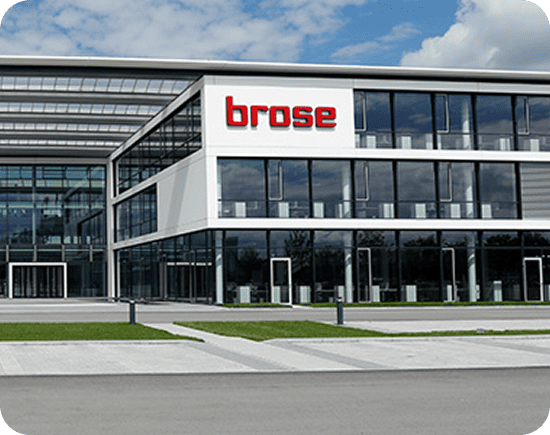 Außenansicht der Brose-Zentrale, die ein modernes Mechatronikgebäude mit Glasfassade und Beschilderung zeigt.